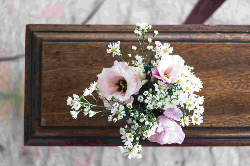 A imagem mostra um vaso de flores em um túmulo, simbolizando o que fazer quando um funcionário falece.