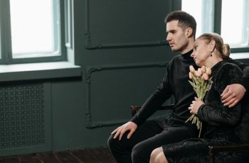 Imagem de duas pessoas se consolado em um velório