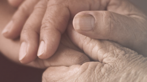 A imagem mostra duas mãos, simbolizando um momento difícil, como por exemplo, ao solicitar um auxílio funeral.