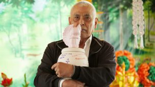 Homem segurando urna de cinzas na mão.