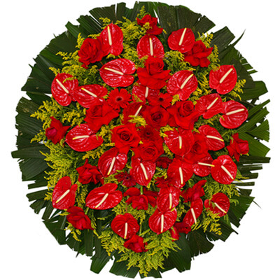 Coroa de flores vermelhas com Antúrios, Gérberas, Rosas Vermelhas, tango, e com uma faixa de homenagem grátis ao centro em diversos tamanhos.
